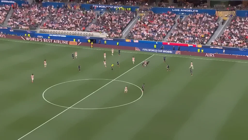 United States vs Paraguay at FIFA World Cup 2026 in Los Angeles — packed stadium with fans, banners, and scoreboard as the US national soccer team defeats Paraguay 4‑1. Players in dark blue (USA) and light uniforms with red accents (Paraguay) compete on the green field under the referee’s watch.